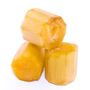 There organic sugar cane cuts isolated on white background. Piece of fresh peel chopped sugar cane sticks chunks with clipping path and copy space