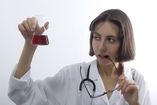 Doctor woman with stethoscope and flask on a white background
