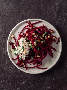 Raw beetroot spaghetti salad with soft cheese,nuts,thyme.Vegetable noodles - Fresh Beetroot Noodles with Ricotta and fresh thyme on plate. Copy space.Clean eating, raw vegetarian food concept.Top view