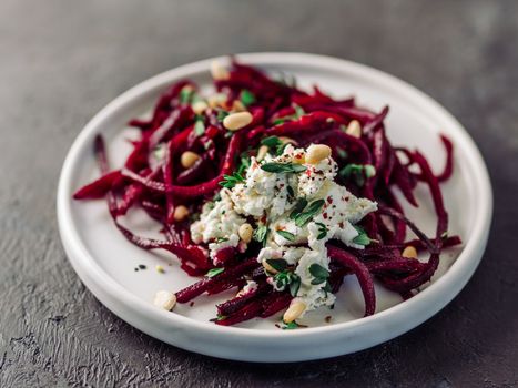 Raw beetroot spaghetti salad with soft cheese, nuts, thyme. Vegetable noodles - Fresh Beetroot Noodles with Ricotta and fresh thyme on plate. Copy space. Clean eating, raw vegetarian food concept