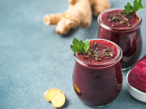 Fresh beetroot and ginger root smoothie. Beetroot smoothie in glass jar on gray table. Shallow DOF. Copy space for text. Clean eating and detox concept, recipe idea.