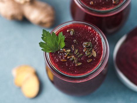 Fresh beetroot and ginger root smoothie. Beetroot smoothie in glass jar on gray table. Shallow DOF. Copy space for text. Clean eating and detox concept, recipe idea. Top view or flat lay.