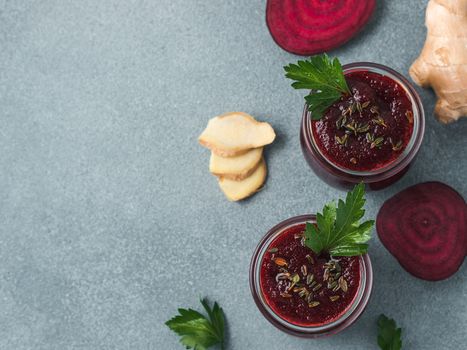 Fresh beetroot and ginger root smoothie. Beetroot smoothie in glass jar on gray table. Shallow DOF. Copy space for text. Clean eating and detox concept, recipe idea. Top view or flat lay.