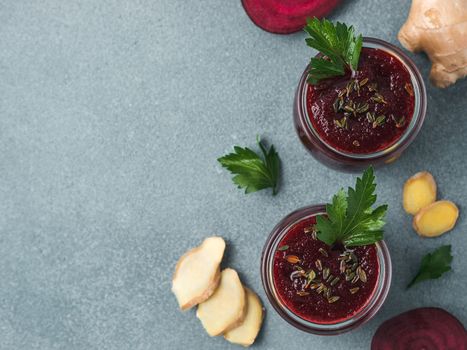 Fresh beetroot and ginger root smoothie. Beetroot smoothie in glass jar on gray table. Shallow DOF. Copy space for text. Clean eating and detox concept, recipe idea. Top view or flat lay.