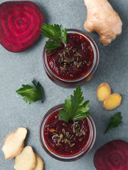 Fresh beetroot and ginger root smoothie. Beetroot smoothie in glass jar on gray table. Shallow DOF. Copy space for text. Clean eating and detox concept, recipe idea. Top view or flat lay.