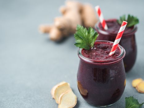 Fresh beetroot and ginger root smoothie. Beetroot smoothie in glass jar on gray table. Shallow DOF. Copy space for text. Clean eating and detox concept, recipe idea.