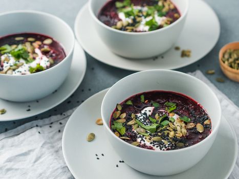 Ideas and recipes for healthy soup - Beetroot and ginger soup puree. Clean eating, detox, vegetarian diet concept. Plates with perfect beet soup, dressed pepitas, sesame and parsley