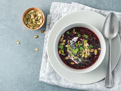 Ideas recipes for healthy soup - Beetroot and ginger soup puree. Clean eating, detox, vegetarian diet concept. Top view of plate with perfect beet soup, dressed pepitas, sesame and parsley. Copy space