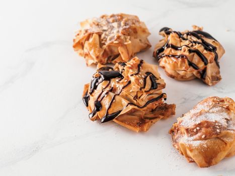 Ideas and recipes for sweet baking. Fillonuts - peanut butter and jelly fillo doughnuts on white marble table. Copy space for text