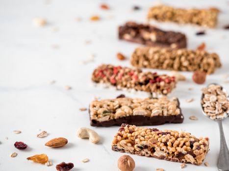 Granola bar with copy space. Set of different granola bars on white marble table. Shallow DOF.
