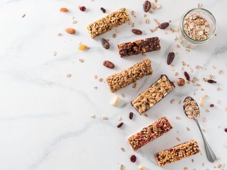 Granola bar with copy space. Set of different granola bars on white marble table. Shallow DOF. Top view or flat lay.