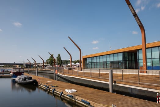 Modern and wooden marina club building in Szczecin, Poland. Boats, motorboat moored at the bank.