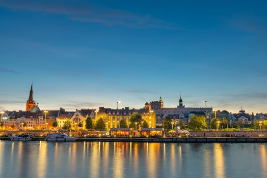 Szczecin. Night view from across the river to the illuminated historic center. Odra river. Chrobry embankments in Szczecin