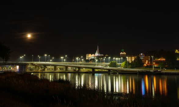 Szczecin. Night view from across the river to the illuminated historic center. Odra river. Chrobry embankments in Szczecin