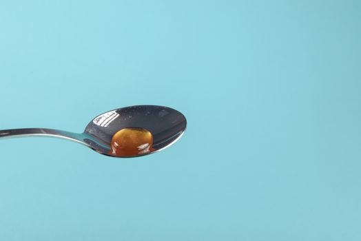close up of honey jar on blue background