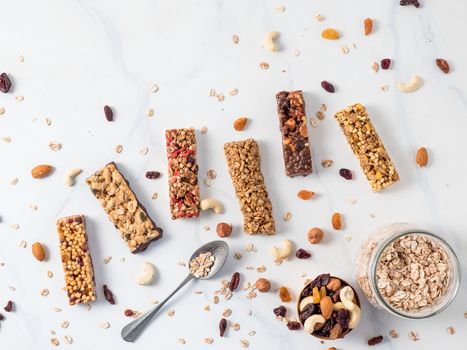 Granola bar with copy space. Set of different granola bars on white marble table. Shallow DOF. Top view or flat lay.