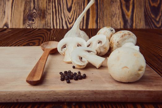 composition poured olive oil, mushrooms, garlic on wooden background. healthy food