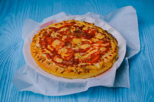 Homemade pepperoni pizza on the table. Tomato, cheese and ham main ingredients.
