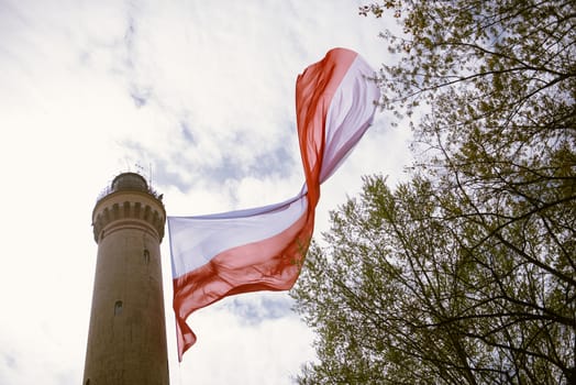Polish flag hung on at historical lighthouse located in Swinoujscie, Poland, The construction was build in 1828 and height is 65 meters. 19th century. Top tallest Lighthouse in the World