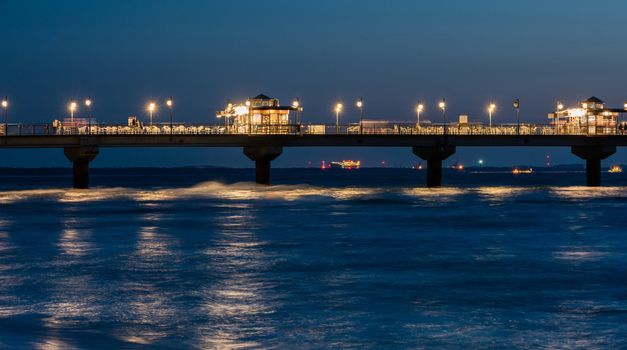 Baltic sea at beautiful sunset in Miedzyzdroje beach, city where the festival of stars takes place every year . Polish baltic coast. Famous city among the tourist. Pier at sunset