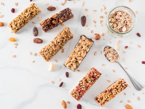 Granola bar with copy space. Set of different granola bars on white marble table. Shallow DOF. Top view or flat lay.