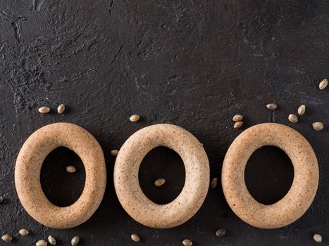 Ring-shaped cracknel with whole grain hemp seed flour and hemp seeds on black background. ring-shaped cracknel close up. Copy space Top view or flat lay.