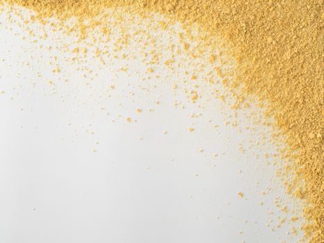 Nutritional yeast on white background. Nutritional inactive yeast top view. Copy space. Nutritional yeast is vegetarian superfood with cheese flavor, for healthy diet