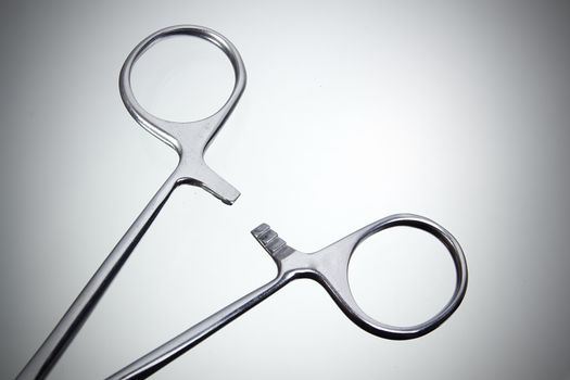 Metal surgical instrument on a gray background