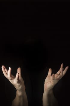 Outraged woman's hands with spread fingers on a black background