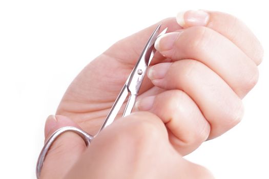 manicure - woman hands with nail scissors to cut nails