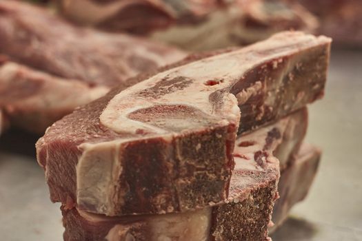 Steaks, calf chops in the foreground with an ingenious detail of the meat fibers, inside a butcher shop.