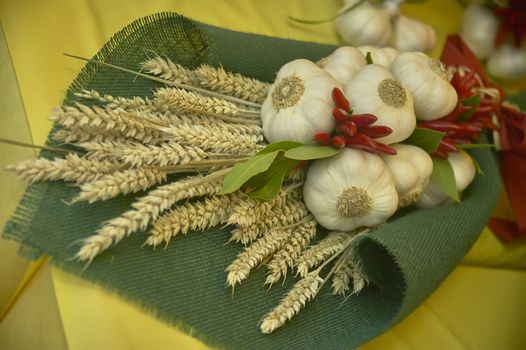 artistic composition for decoration purpose made up of garlic, grain, peproncino and laurel used to beautify spaces of a grocery store.