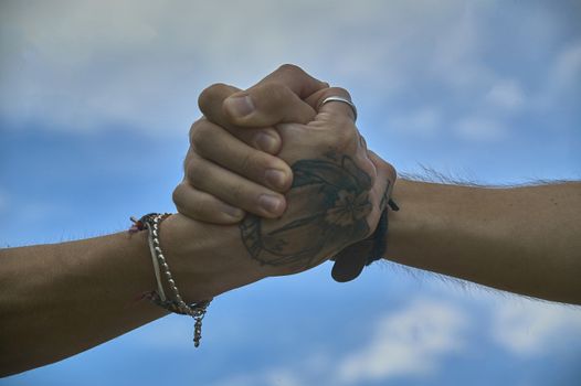 Handshake between two friends: symbol of peace, union, friendship, brotherhood and unity.