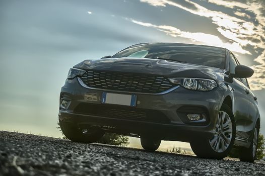 Modern car shot from below with wide angle behind with sunset and a beautiful light that contrasts.