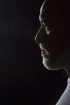 Silhouette profile of a man with a beard on a black background