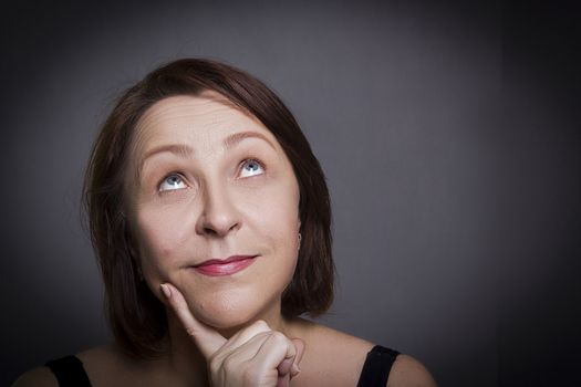 Woman grimaces in front of camera on gray background