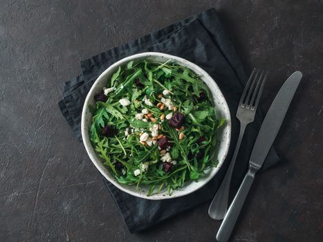 Beetroot, aragula and soft cheese salad over black background. Top view or flat lay. Copy space for text. Idea and recipe for healthy vegetarian salad. Clean eating diet concept