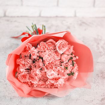 Beautiful bouquet with roses, dianthus, hypericum, clove in color of year 2019 Living Coral concept. Trendy color Living Coral in flowers, wedding bouquet. Square format