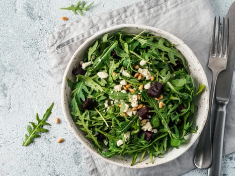 Beetroot, aragula and soft cheese salad over gray background. Top view or flat lay. Copy space for text. Idea and recipe for healthy vegetarian summer salad. Clean eating diet concept