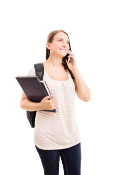 Smiling beautiful young student girl with a backpack, holding books and talking on a phone, isolated on white background.