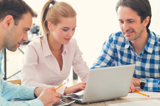 Business team work together looking at one laptop at workplace