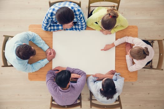 Hipster business teamwork brainstorming planning meeting concept, people team sitting around the table with white paper and pointing, copy space