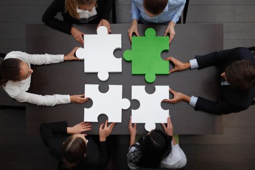 Group of business people assembling jigsaw puzzle, team support and help concept