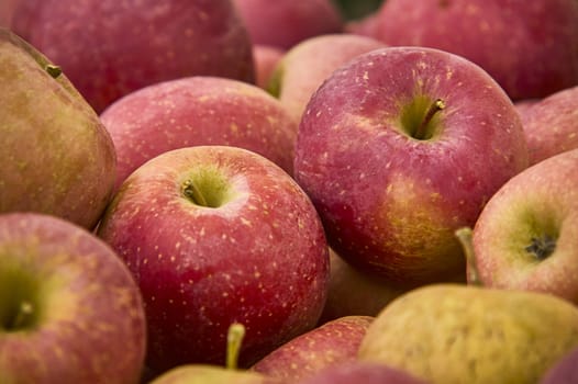 Many red apples in a basket at the market.