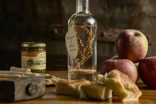 Table full of healthy food as usual: apples, grappa, bread and jam: Traditional Italian food pie table. Horizontal shot.