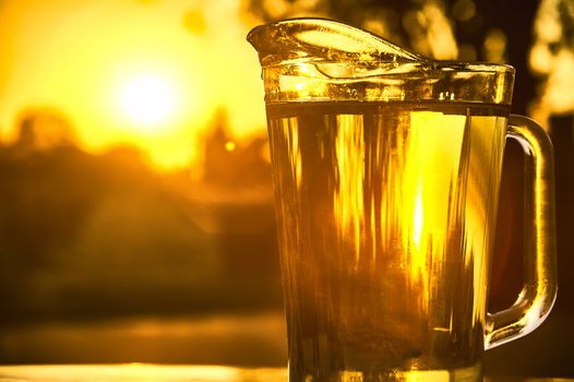 Pitcher of cool water shooting against the light on a beautiful sunset.