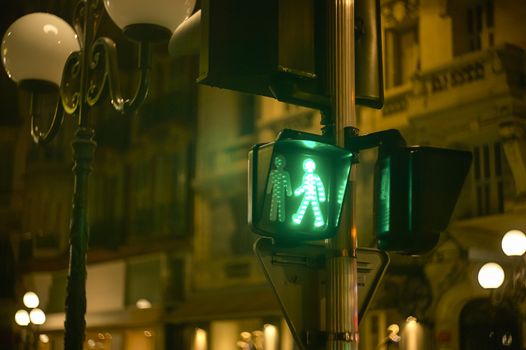 Green pedestrian traffic light in a characteristic street of Nice in France.