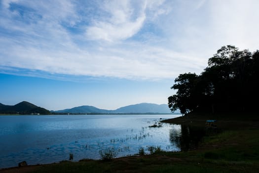 silhouette of bank with white cloudy and lake