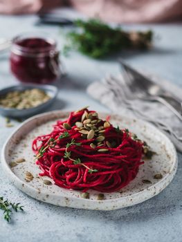 Beetroot pesto or hummus. Homemade beet pesto sauce in glass jar and fresh thyme on dark black background. Copy space for text. Ideas and recipes for healthy vegetarian detox diet food