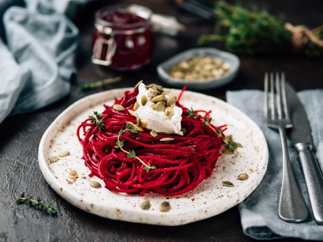 Beetroot pesto or hummus. Homemade beet pesto sauce in glass jar and fresh thyme on dark black background. Copy space for text. Ideas and recipes for healthy vegetarian detox diet food